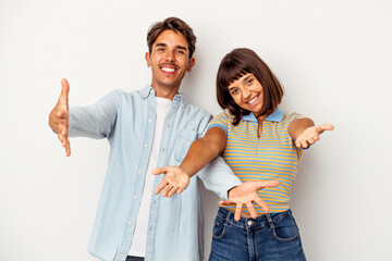 Young mixed race couple isolated on white background showing a welcome expression.