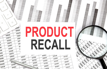 PRODUCT RECALL text on paper with calculator,pen on graph background
