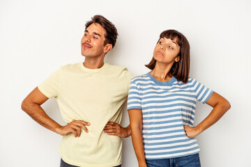 Young mixed race couple isolated on white background dreaming of achieving goals and purposes