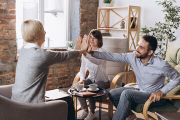 Meeting with psychologist. Happy married couple, young man and woman talking with consultant about life