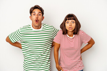 Young mixed race couple isolated on white background being shocked because of something she has seen.