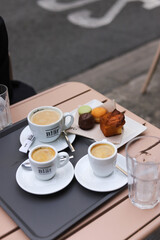cup of coffee and cupcakes on a table