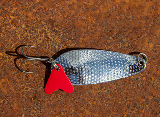 Fishing lure for catching predatory fish on a rusty background close-up view from above. White...