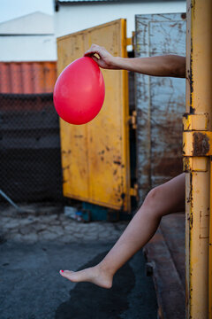 Woman holding red balloon outdoors