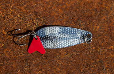 Fishing lure for catching predatory fish on a rusty background close-up view from above. White...