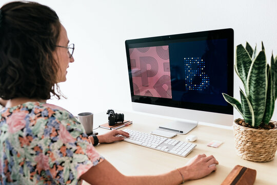 Female designer using computer in light studio