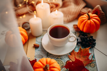 autumn flatlay presented by a cup of coffee, candles, pumpkins, illumination, scarf