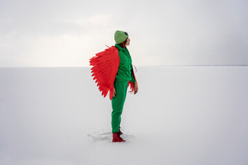 Woman in green bird costume on snow