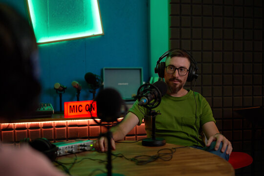 Male podcaster recording audio in studio