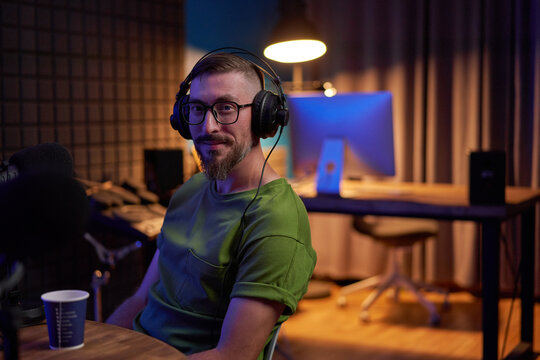 Male podcaster recording audio in studio