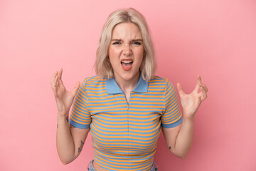 Young caucasian woman isolated on pink background screaming with rage.