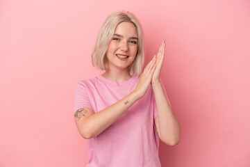 Young caucasian woman isolated on pink background feeling energetic and comfortable, rubbing hands confident.