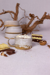 A cup of cocoa with cream and chocolate on a light background