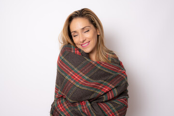 Fototapeta premium Portrait of a pretty young woman in winter clothing hugging herself. Concept of selfish emotion.