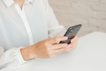 using cell phone hand holding mobile texting message contact us.chatting,search internet information in office.technology device communication connecting