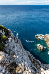 Rocky steep cliff look down on blue vivid Ionian seascape background. Summer nature in Lefkada island, Greece