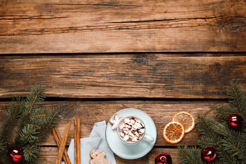 Flat lay composition of delicious hot chocolate with marshmallows and Christmas decor on wooden table, space for text