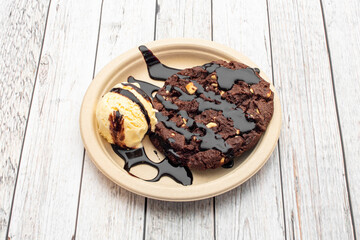 Chocolate hazelnut cookie with scoop of vanilla ice cream with chocolate syrup
