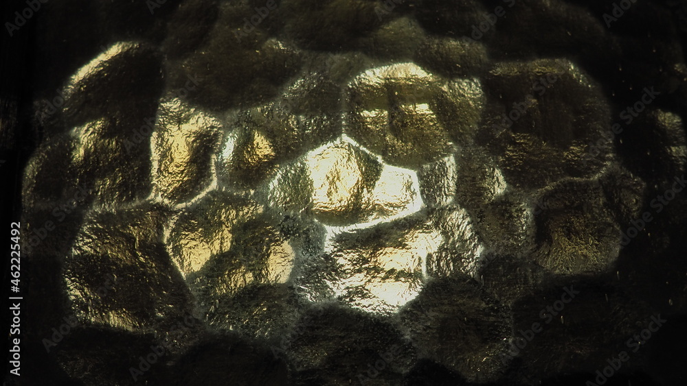 Poster corrugated glass, rear light source. play of glare and reflections on a transparent uneven surface. 