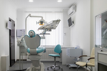 Inside the white and clear dentist's cabinet. Armchairs and apparatus in front of the window.