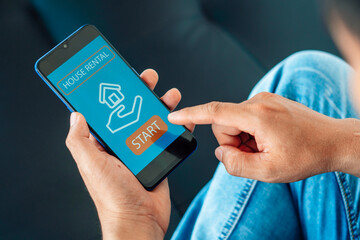 man searching for apartment on rental property website via smartphone, closeup