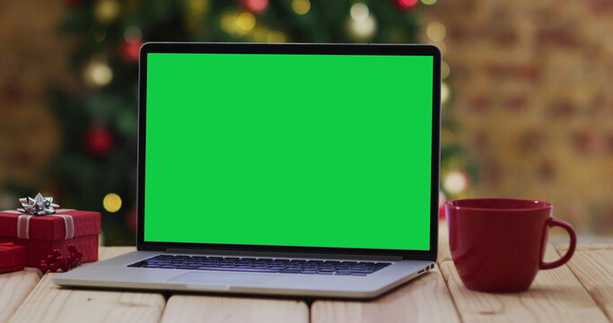Laptop with green screen on screen, with christmas decorations and tree - Powered by Adobe