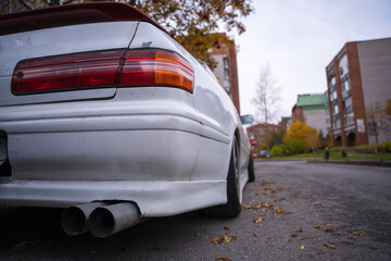 An old classic Japanese car in an autumn urban landscape, popular sedan made in Japan parking on...