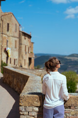 Seen from behind modern traveller woman in Tuscany, Italy