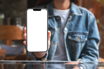 Mockup image of a woman holding and showing a mobile phone with blank white screen