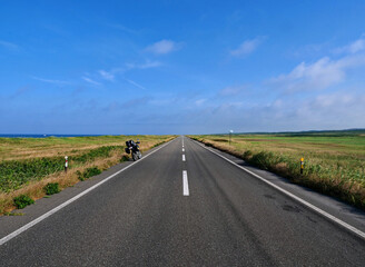 地平線へ続く一本道とバイク
