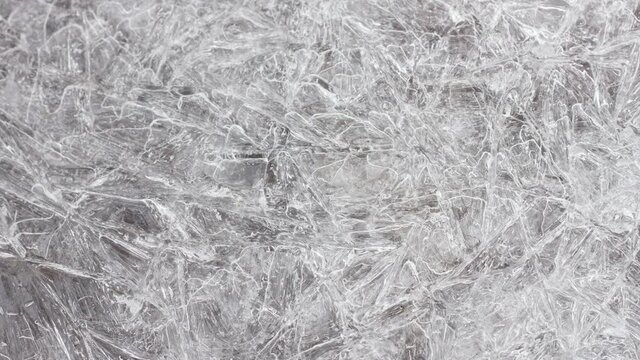 closeup, ice texture with many cracks, slow motion, natural natural background.
