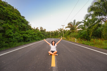 Young asia woman sit on the middle of road