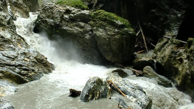 A powerful water stream in a narrow gorge, leads the snow and rain water from the mountains. a 4K video clip, Liechtensteinklamm, Austria.