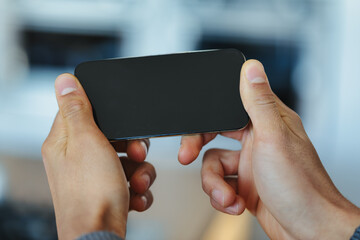 Black man holding a blank smartphone horizontally