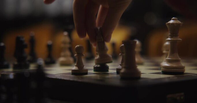 A young woman plays a chess game alone, close-up