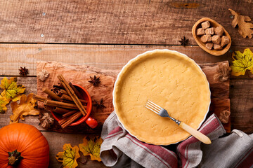 Pumpkin and food ingredients, spices, cinnamon and kitchen utencil on old rustic wooden background. Concept homemade baking for holiday. Cooking pumpkin pie and cookies for Thanksgiving day.