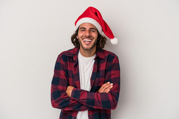 Young caucasian man celebrating Christmas isolated on gray background laughing and having fun.