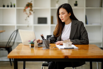 Asian business woman real estate agent home loan working at the office. signs a purchase contract or mortgage for a home, Real estate concept.