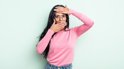 pretty hispanic woman covering face with both hands saying no to the camera! refusing pictures or...