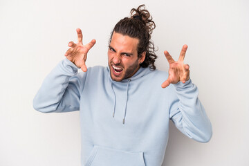 Young caucasian man isolated on gray background upset screaming with tense hands.