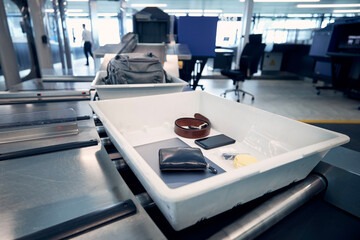 Personal Items, liquids, and laptop in container at airport security check before flight..