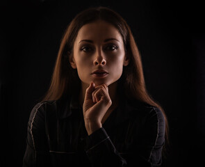 Serious concentration intelligence business woman in darkness looking with fist under the face and...