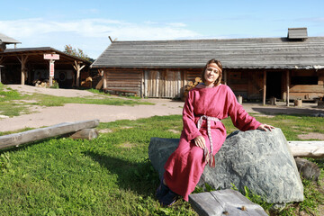 Naklejka na ściany i meble Woman in Scandinavian folk clothes on stone