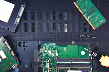 A repair laptop computer with a hard disk and RAM in the background (Random Access Memory)