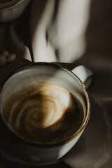 Still Life cup of coffee, bean coffee on wooden spoon and bowl of ground coffee and sugar on beige background