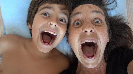 Fethiye, Turkey - 7th of October 2021: 4K Comic mother and son making funny grimaces on camera
