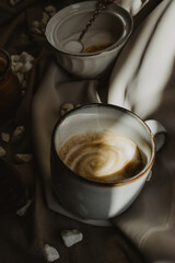 Still Life cup of coffee, bean coffee on wooden spoon and bowl of ground coffee and sugar on beige background