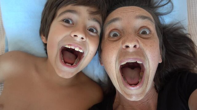 Fethiye, Turkey - 7th of October 2021: 4K Comic mother and son making funny grimaces on camera
