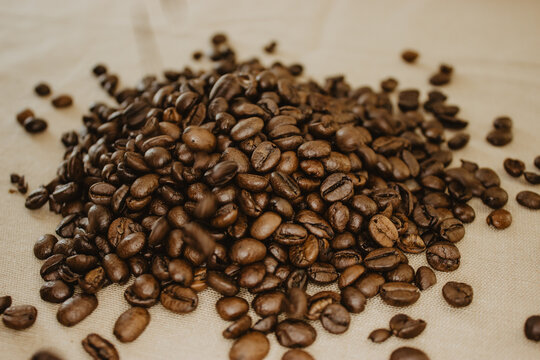 Close-up image of amount coffee bean in a background beige isolated.