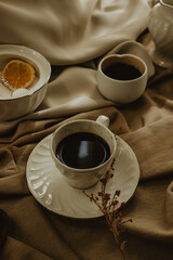 Still Life of hot coffee, sugar and ground coffee on brown background.